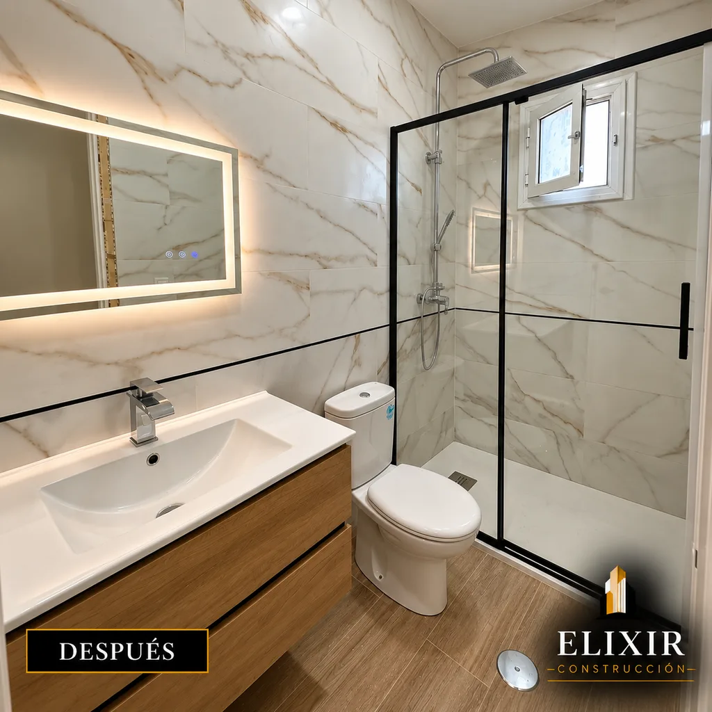 Baño terminado con ducha a ras y mampara negra, obra de Elixir Construcción en Sevilla